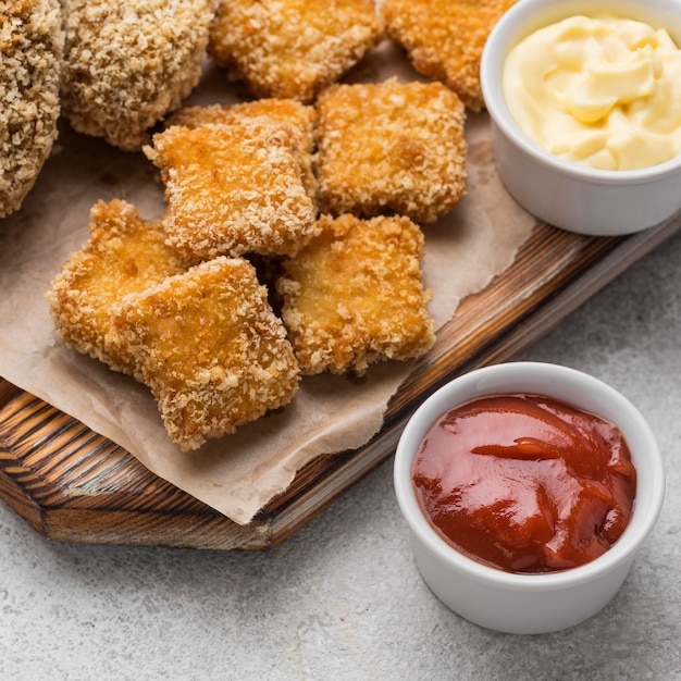 Alto ángulo de nuggets de pollo frito con dos salsas diferentes