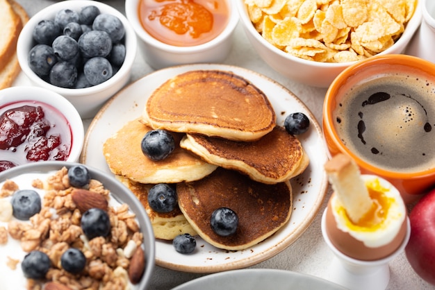 Alto ángulo de panqueques con arándanos y cereales para el desayuno