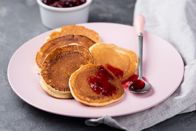 Alto ángulo de panqueques en un plato para el desayuno con mermelada