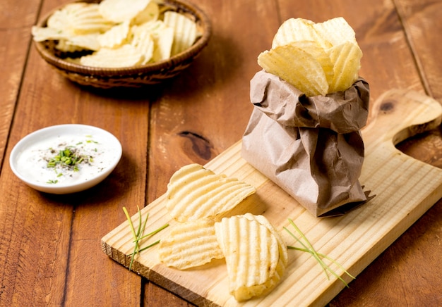 Alto ángulo de papas fritas en bolsa de papel con salsa