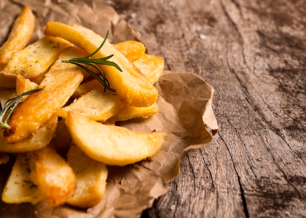 Alto ángulo de papas fritas con hierbas y espacio de copia