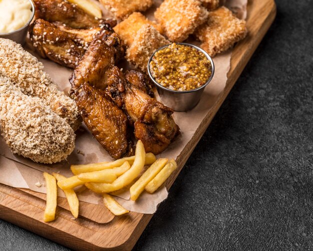 Alto ángulo de papas fritas con pollo frito y nuggets