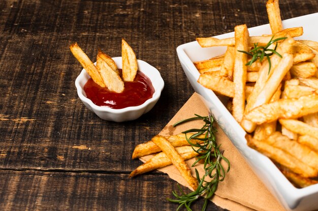 Alto ángulo de papas fritas y salsa de tomate