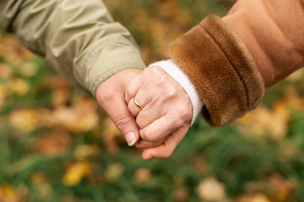 Alto ángulo pareja senior cogidos de la mano