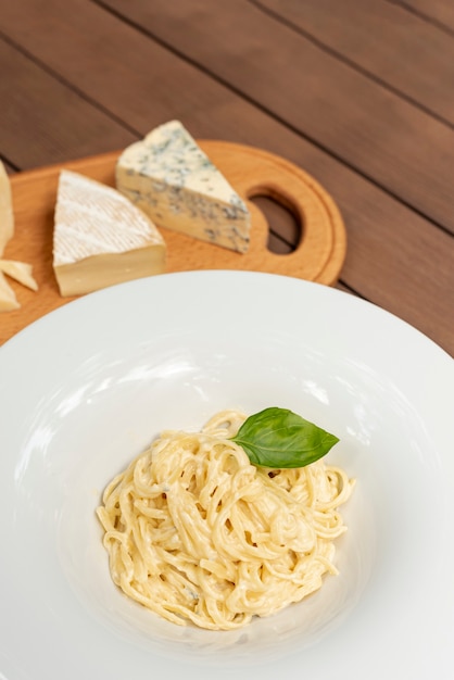 Foto gratuita alto ángulo de pasta carbonara en mesa de madera