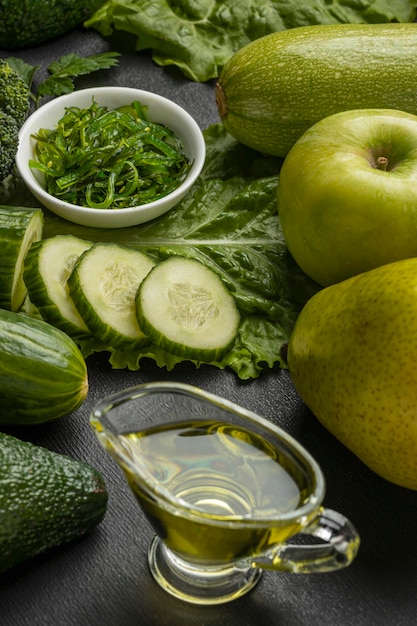 Alto ángulo de pepinos con brócoli y aceite.