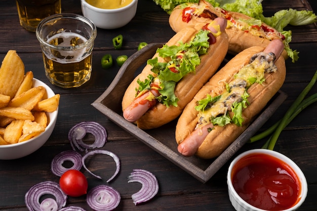 Alto ángulo de perros calientes con patatas y salsa de tomate