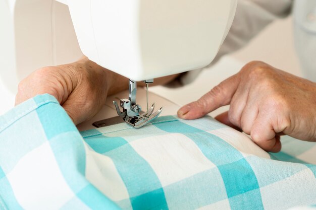 Alto ángulo de persona con máquina de coser y textil