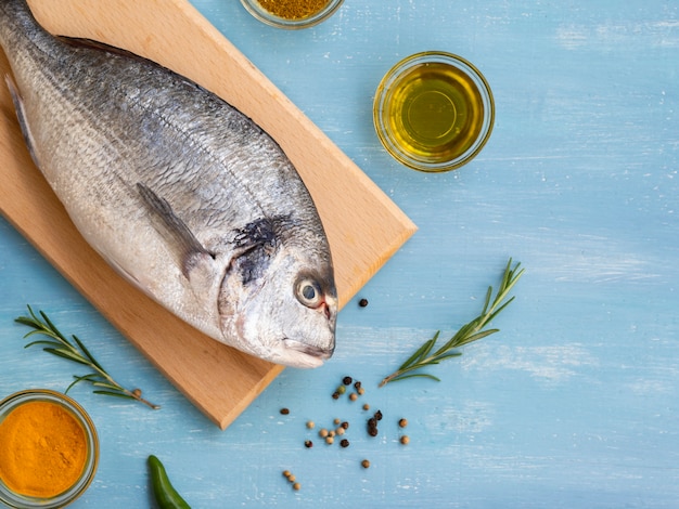 Foto gratuita alto ángulo de pescado fresco en una tabla de madera