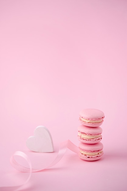 Foto gratuita alto ángulo de pila de macarons con corazón y cinta