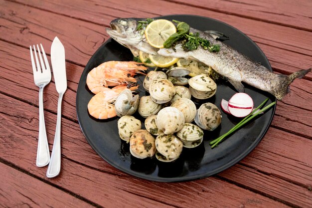 Alto ángulo de plato con pescado y almejas