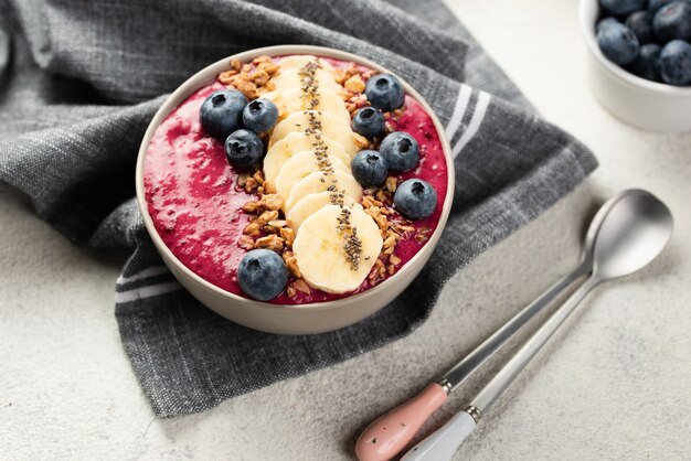 Alto ángulo de postre de desayuno en un tazón con rodajas de plátano y cereal