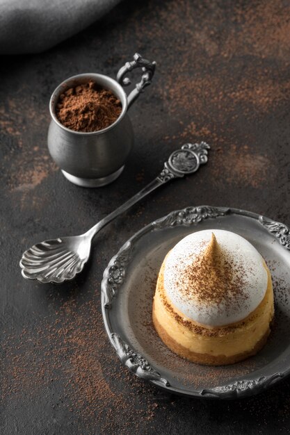 Alto ángulo de postre en un plato con cacao en polvo