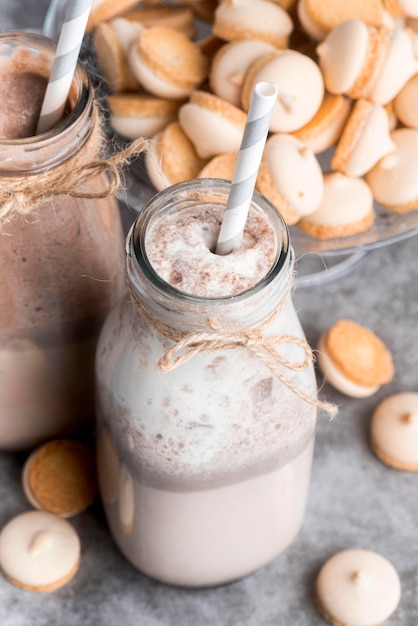 Alto ángulo de postres con pajitas y macarons