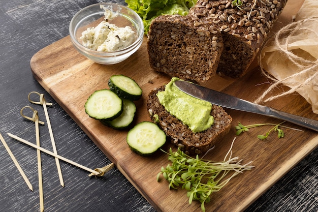 Alto ángulo de rebanada de pan para sándwich con pepinos