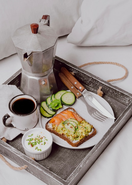 Foto gratuita alto ángulo de sándwich de desayuno en la cama con salmón y pepino