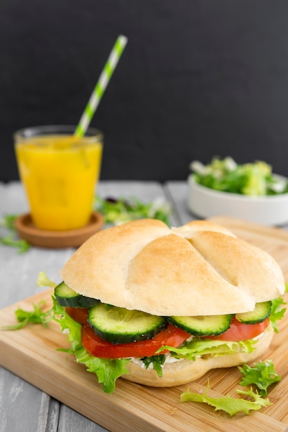 Alto ángulo de sándwich con jugo de naranja desenfocado