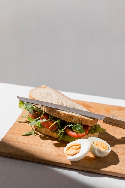 Alto ángulo de sándwich tostado con tomates, huevo duro y espacio de copia