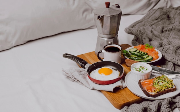 Alto ángulo de sándwiches de desayuno en la cama con huevo frito y espacio de copia