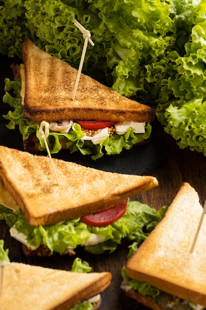 Alto ángulo de sándwiches de ensalada y tomates triangulares