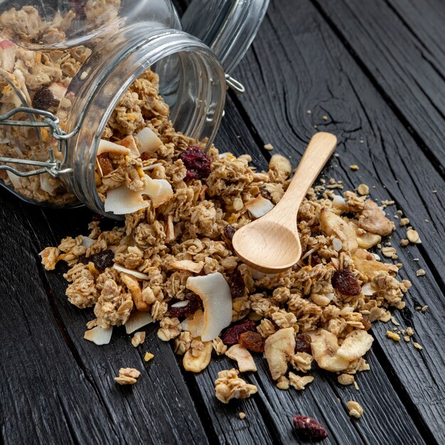 Alto ángulo de tarro con cereales para el desayuno y cuchara