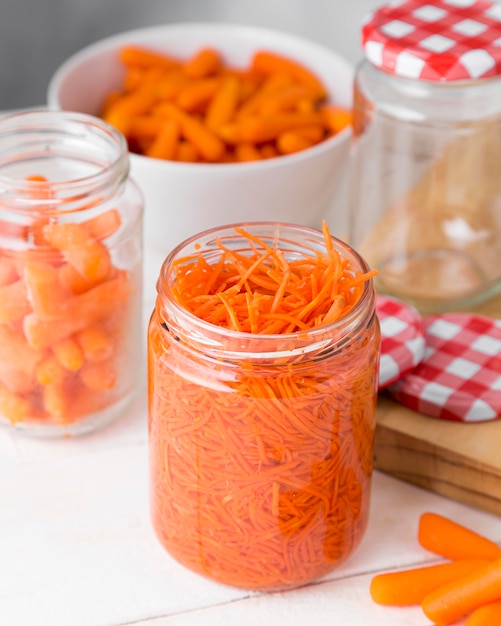 Alto ángulo de tarro de cristal con zanahorias pequeñas picadas