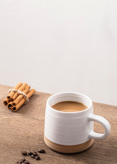 Alto ángulo de taza de café con canela y copie el espacio