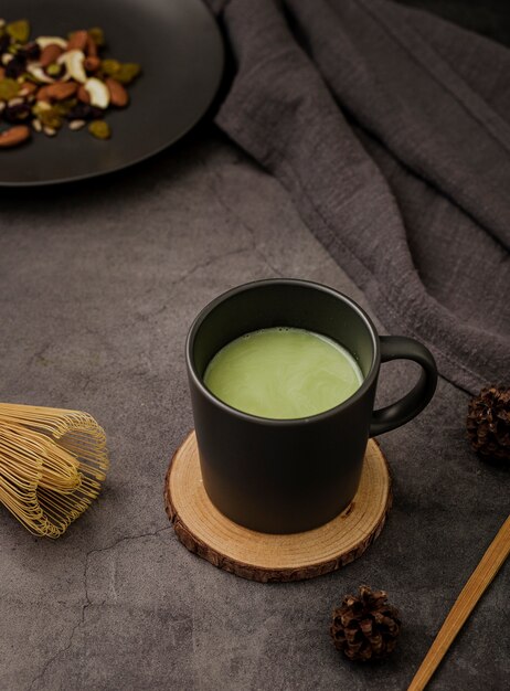 Alto ángulo de la taza de té matcha en posavasos