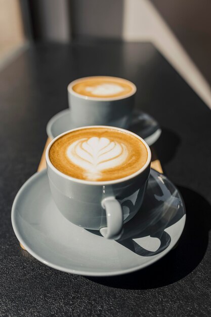 Alto ángulo de tazas de café decoradas hechas por barista