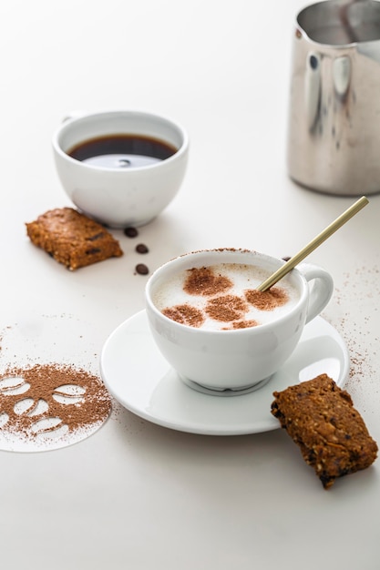 Alto ángulo de tazas de café con postre y plato