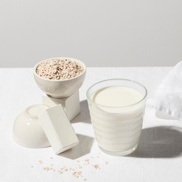 Alto ángulo de tazón con avena y vaso de leche