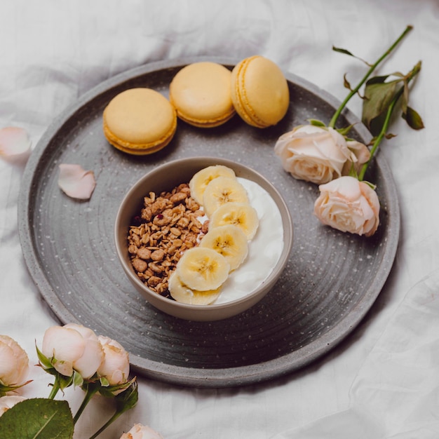 Alto ángulo de tazón de desayuno con cereales y macarons