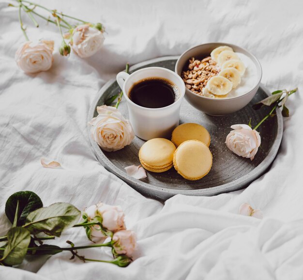 Alto ángulo de tazón de desayuno con macarons y café