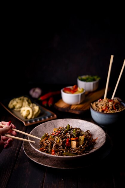 Alto ángulo de tazón de fideos con otra comida asiática