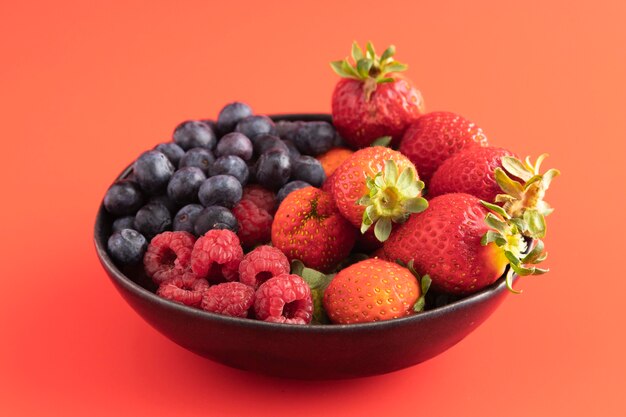 Alto ángulo de tazón con fresas, arándanos y frambuesas