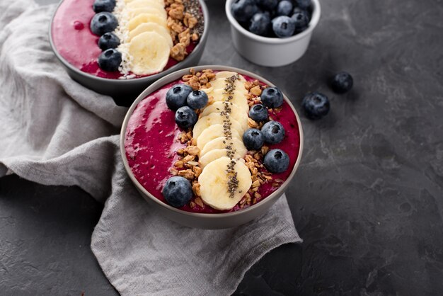 Alto ángulo de tazones con postres de desayuno y variedad de frutas y cereales.