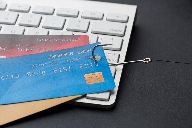 Alto ángulo de teclado con tarjetas de crédito y gancho para phishing