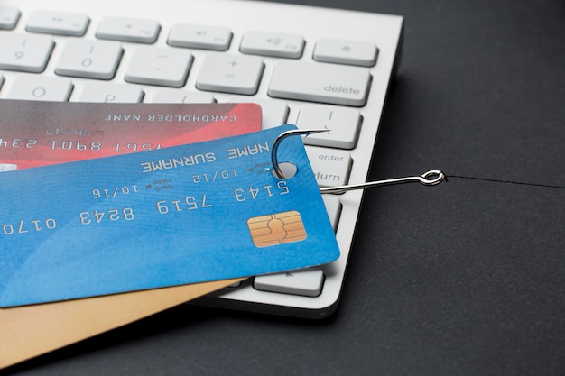 Alto ángulo de teclado con tarjetas de crédito y gancho para phishing