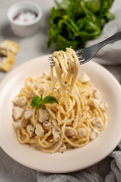 Alto ángulo de tenedor y deliciosa pasta