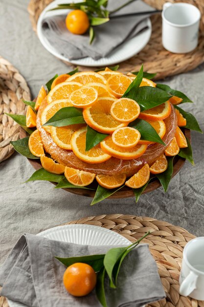 Alto ángulo de torta con rodajas de naranja y hojas