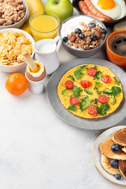 Alto ángulo de tortilla con cereales y panqueques para el desayuno.