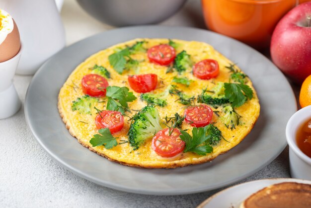 Alto ángulo de tortilla en plato con tomates para el desayuno