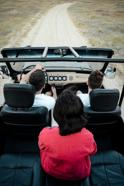 Alto ángulo de tres amigos viajando juntos en coche