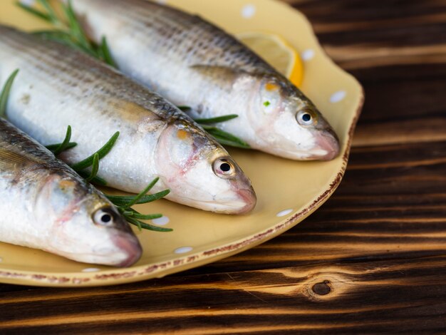 Alto ángulo de tres peces en un plato con hierbas