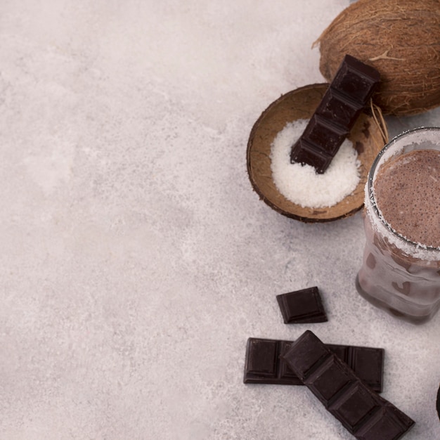 Foto gratuita alto ángulo de vaso de batido de chocolate con coco y espacio de copia