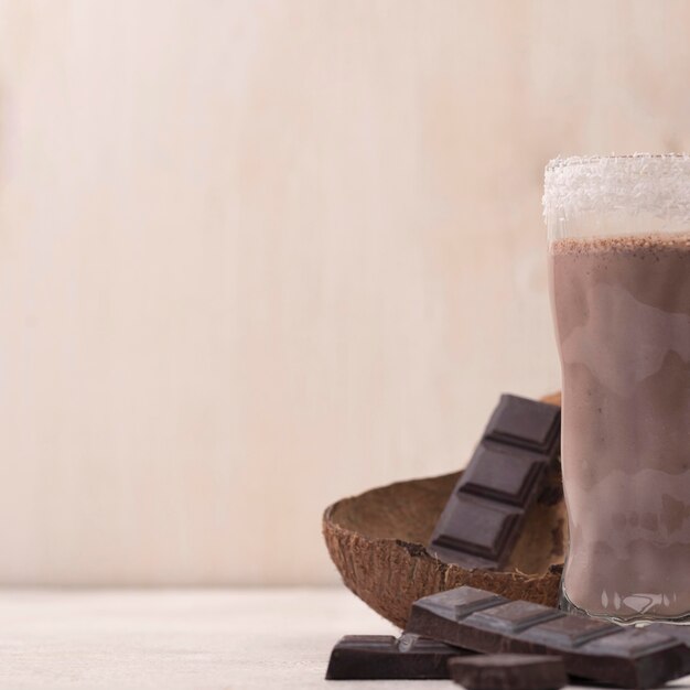 Alto ángulo de vaso de batido de chocolate con espacio de copia y coco