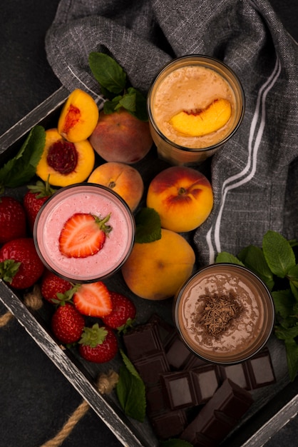 Foto gratuita alto ángulo de vasos de batido en bandeja con frutas y chocolate