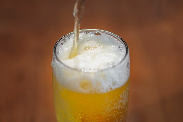 Alto ángulo vertiendo cerveza en medio litro sobre la mesa