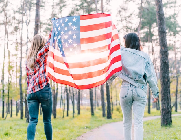 Alumnas sosteniendo la bandera de Estados Unidos al aire libre