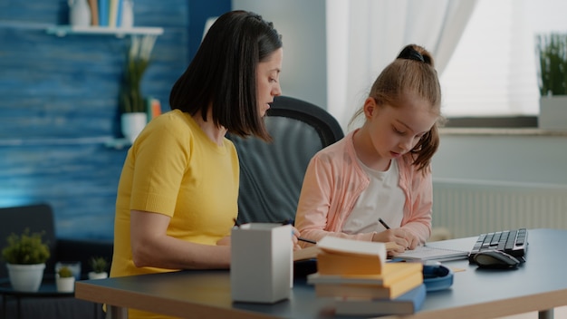 Alumno y madre haciendo los deberes junto con libros